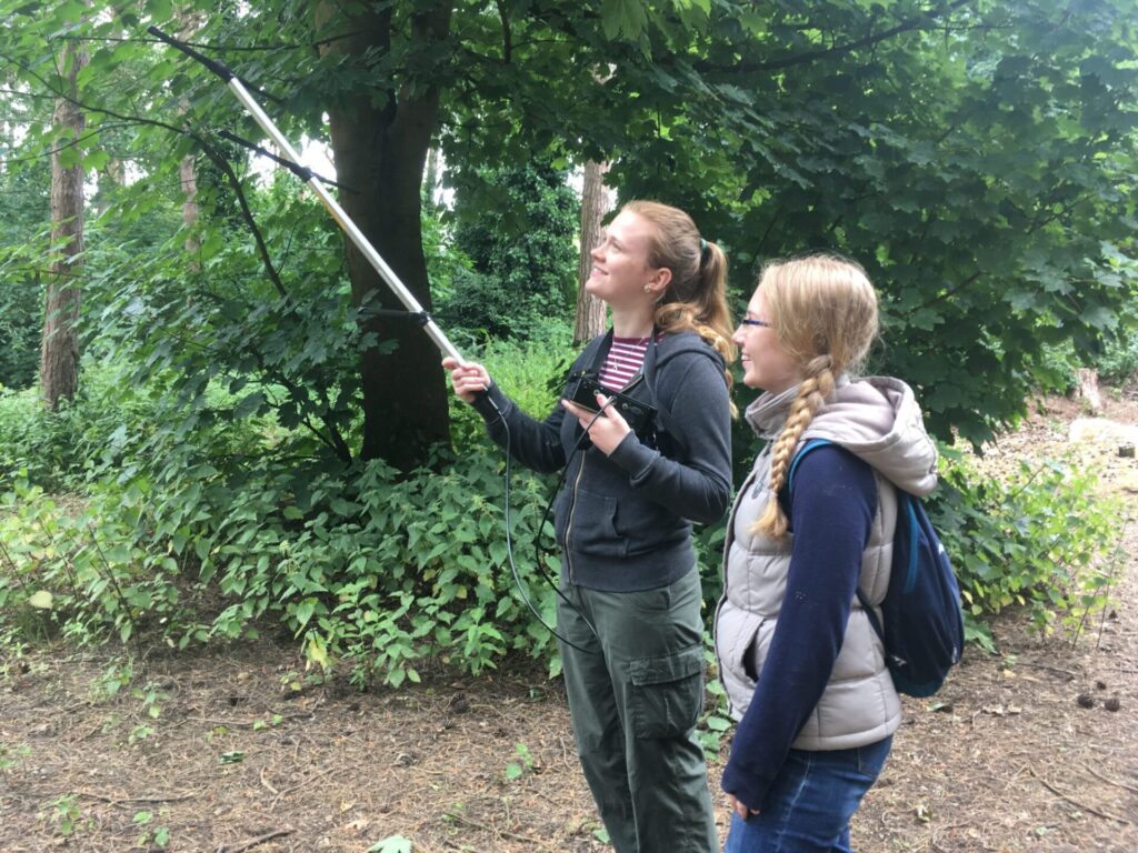 two women in woodland holding aerial