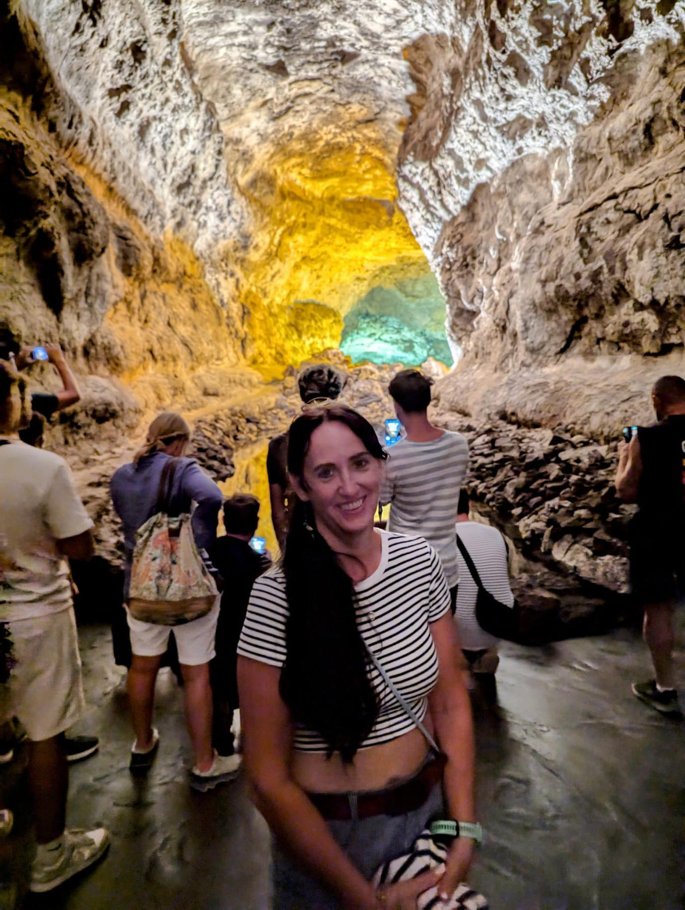 Jen in a cave, smiling at the camera.